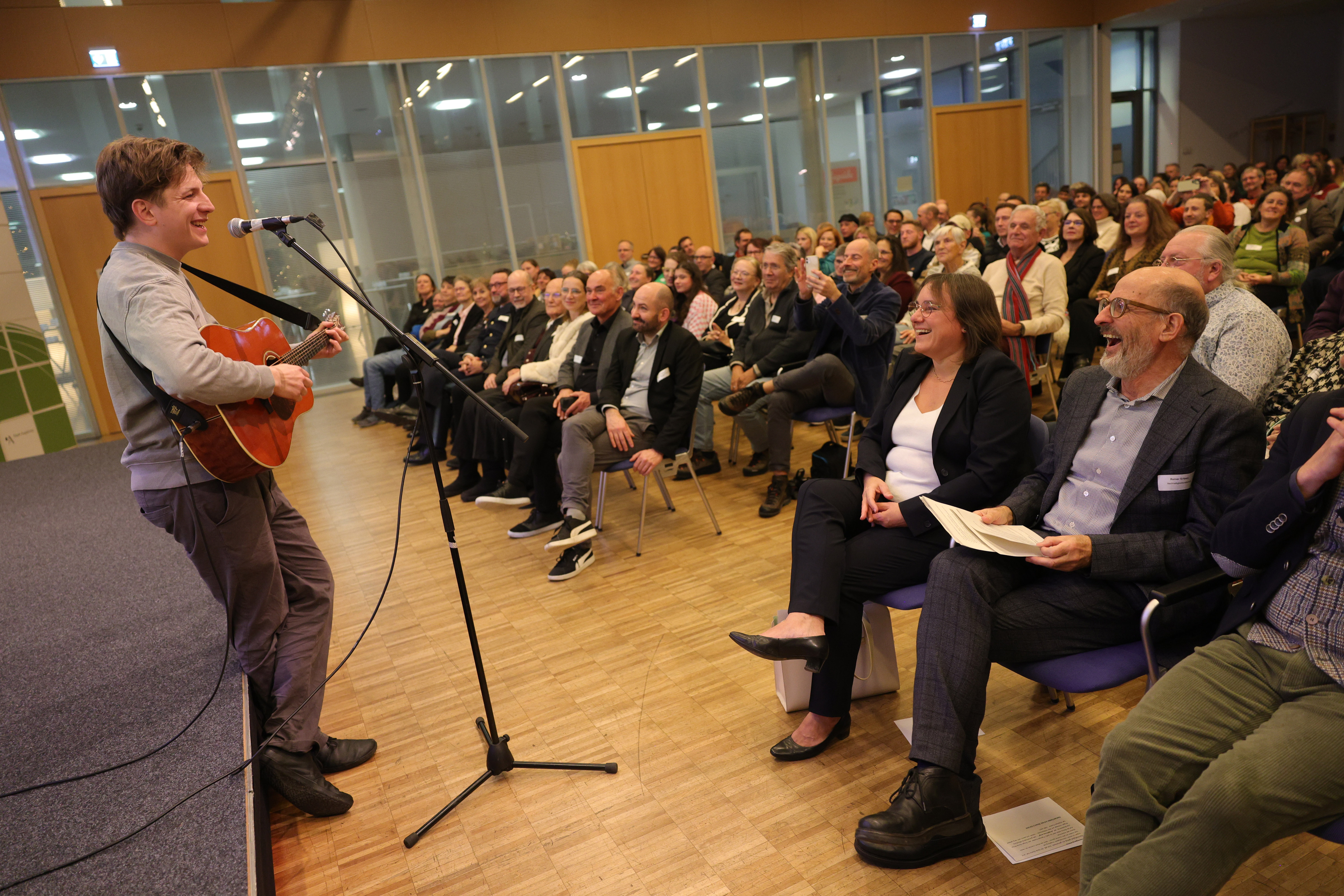 Foto vom Musiker Raphael Kestler mit seiner Gitarre vor den Gästen der Preisverleihung der Augsburger Zukunftspreise 2025.