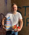 Ein Abholer zeigt stolz die von der Foodcoop abgeholten Lebensmittel. © Genusskollektiv