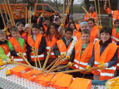 Hier sieht man Kinder als fleißige Helfer*innen von der Müllsammelaktion "Augsburg - Sauber ist in!" im Jahr 2024 in ihrer neon-orangen Warnweste mit passendem Equipment.