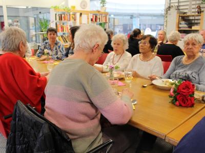 Seniorinnen essen im Wohnzimmer im Schwabencenter das aus der KUKA Betriebskantine gerettete Essen.