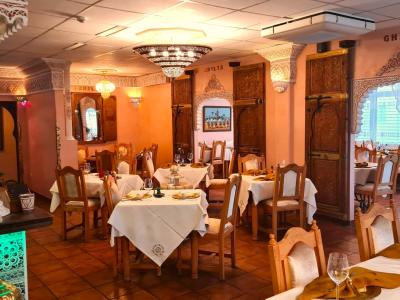 Innenraum des marokkanischen Bio-Restaurants BIODuMAROC in Augsburg mit orientalischen Stuckverzierungen, Kronleuchtern und festlich gedeckten Tischen