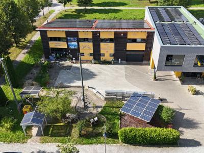 Luftaufnahme des Firmengeländes von Hörmann Solartechnik mit Photovoltaikanlagen auf dem Dach und Solarmodul-Ausstellung im Außenbereich.