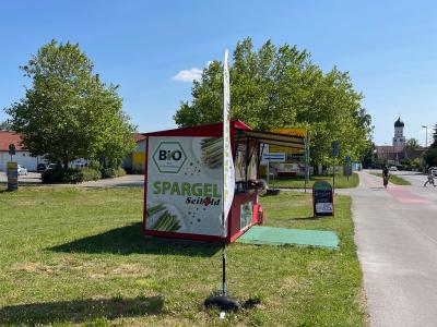 erkaufsstand von Biohof Seibold mit Bio-Spargel-Banner an der Straße in Inningen