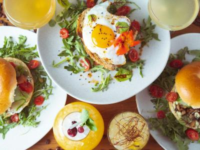 Detail eines Brunchs mit Eiern, Tomaten, Gemüse, Toast und Bagels.   
