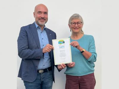 Gesellschafts-Referent Martin Schenkelberg und Ute Michallik von der Steuerungsgruppe Fairtrade-Stadt Augsburg präsentieren die Urkunde zur erneuten Auszeichnung der Stadt Augsburg als Fairtrade-Stadt. Foto: Torsten Mertz