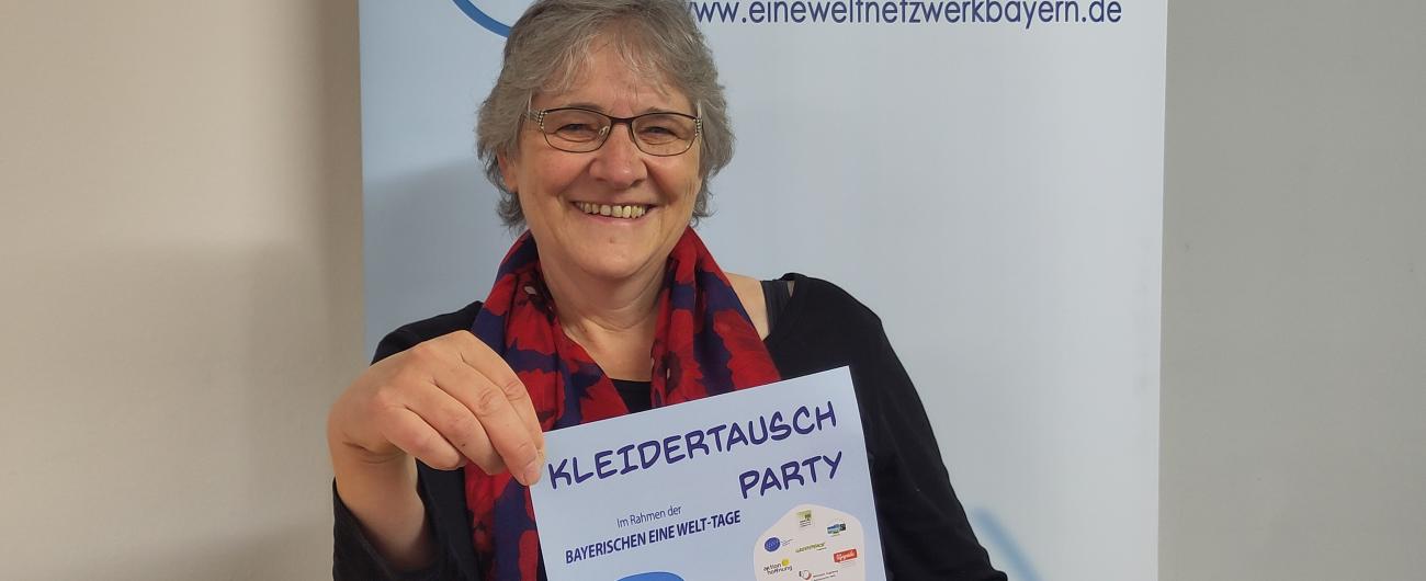 Die Organisatorin der Eine Welt-Tage in Augsburg Annegret Lueg mit dem Poster für die Kleiderauschbörse am Samstag.