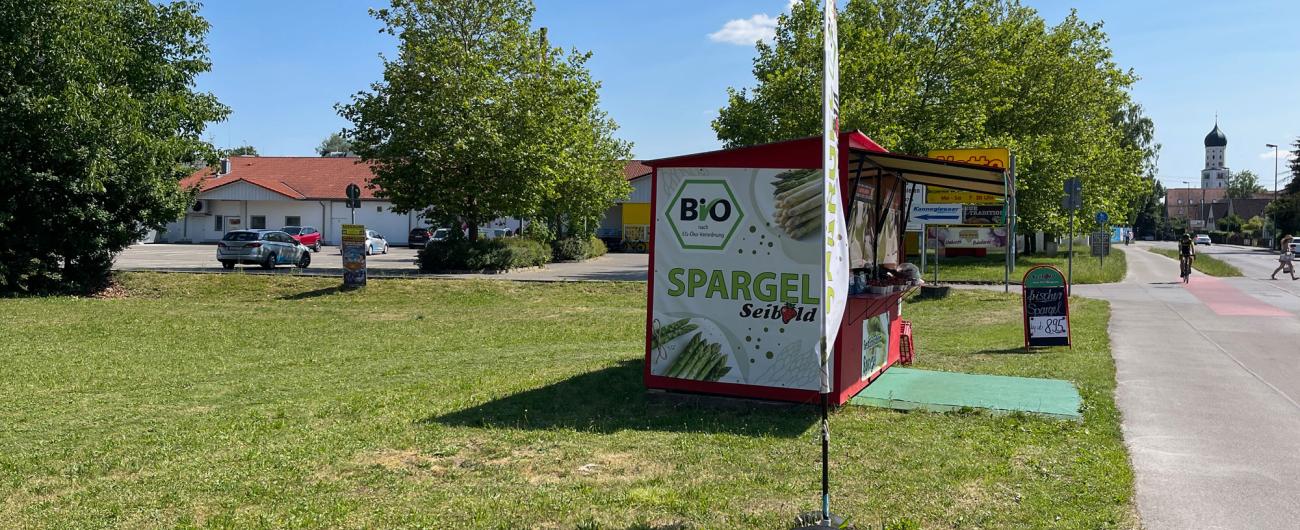 erkaufsstand von Biohof Seibold mit Bio-Spargel-Banner an der Straße in Inningen