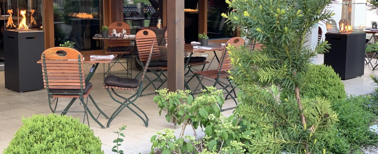 Terasse mit Tischen, Stühlen und Garten des Landgasthofs Kühner.
