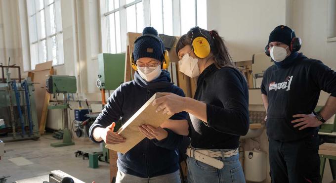 Projektberatung im Habitat: Zwei Frauen begutachten ein Holzstück