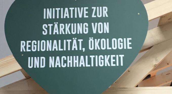 Schild "Initiative zur Stärkung von Regionalität, Ökologie und Nachhaltigkeit" auf dem Stand des Herzstücks.