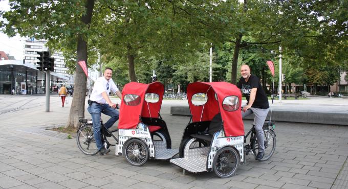 Am Königsplatz stellten Sozialreferent Martin Schenkelberg (rechts) und Manuel Heckmann, Dienststellenleiter der Malteser in Augsburg, den Rikscha-Dienst vor. Bild: Christiane Martin, Malteser Hilfsdienst e.V.