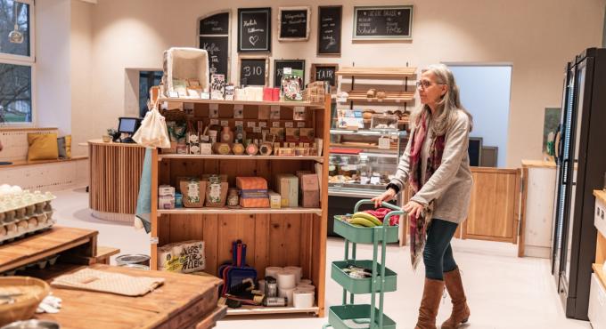 Frau kauft mit Wagen für unverpackte Lebenmittel im Hofladen Schloss Blumenthal ein.