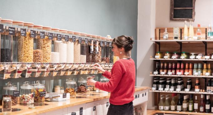 Frau kauft unverpackte Lebensmittel aus Schütten im Hofladen Schloss Blumenthal.