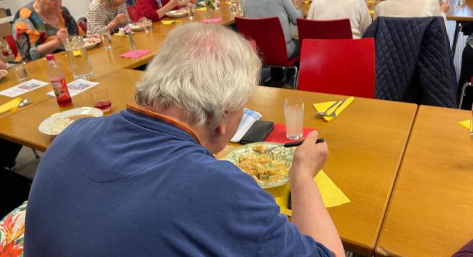 Mann im Wohnzimmer im Schwabencenter Augsburg isst gerettetes Essen aus der Betriebskantine der KUKA AG