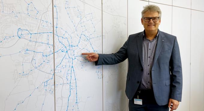 swa-Chef Rainer Nauerz deutet auf den Linienplan des öffentlichen Nachverkehrs in Augsburg.