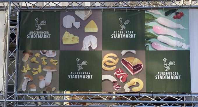 Das Bild zeigt ein Plakat auf dem die Produkte wie Käse, Gemüse und Fleisch des Stadtmarktes abgebildet sind. Bild Katrin Jacob