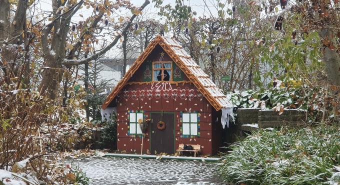 Foto zeigt den märchenhaften Botanischen Garten Augsburg. Foto einer kleinen Hütte die aussieht wie ein Lebkuchenhaus.