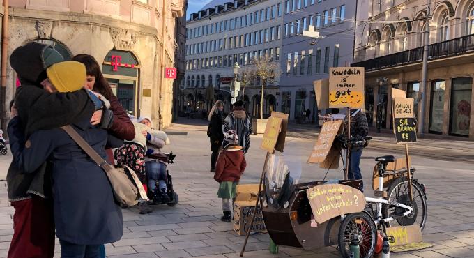 Der Aktionsstand der Cushelcrew in Augsburg am Königsplatz. Hier verschenken sie zum Welt-Knuddel-Tag am 21. Januar Umarmungen.