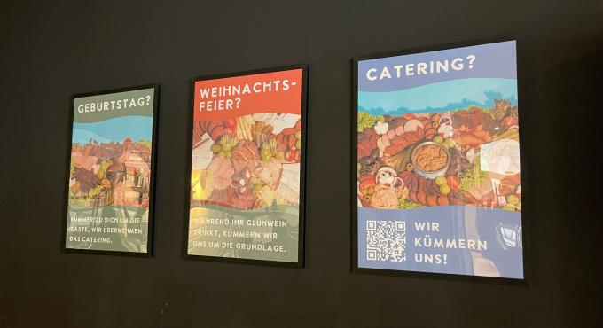 Drei beleuchtete Werbeplakate an dunkler Wand mit den Aufschriften „Geburtstag?", „Weihnachtsfeier?" und „Catering?" der Veganen Fleischerei.